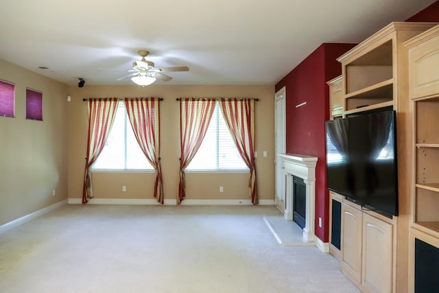 unfurnished living room with light carpet and ceiling fan