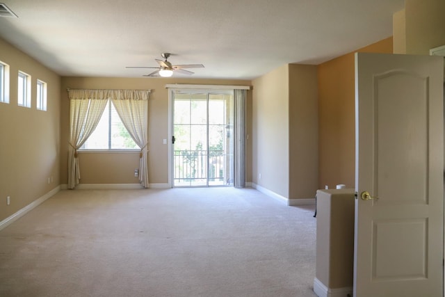 carpeted spare room featuring ceiling fan