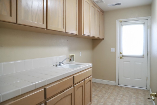 clothes washing area with washer hookup, cabinets, and sink