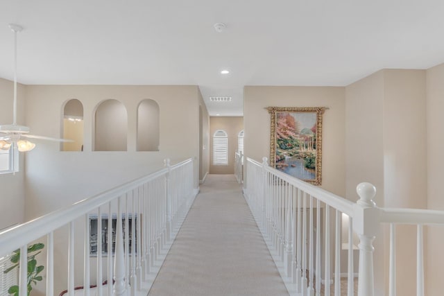 hallway featuring light colored carpet