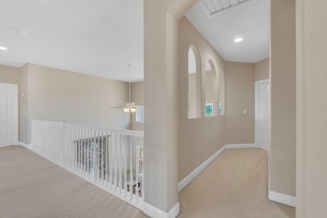 corridor featuring plenty of natural light and light carpet