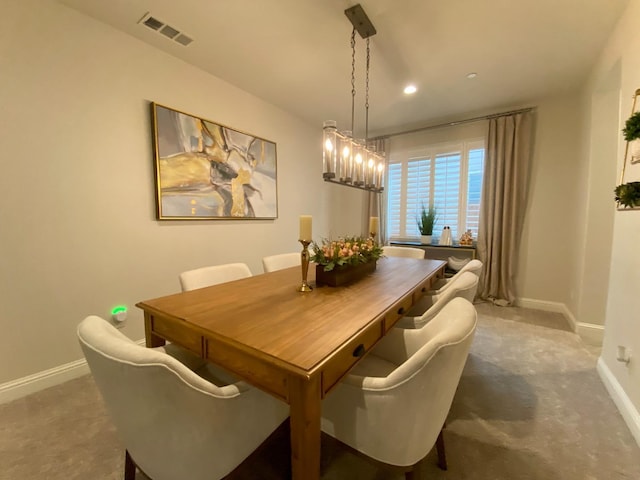 dining space featuring dark carpet and an inviting chandelier