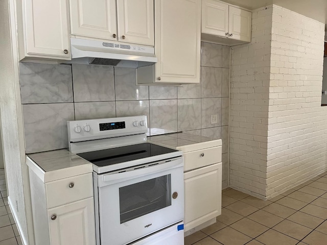 kitchen with white cabinets, light tile patterned floors, and white electric stove