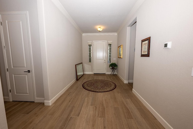 foyer entrance with ornamental molding and light hardwood / wood-style floors