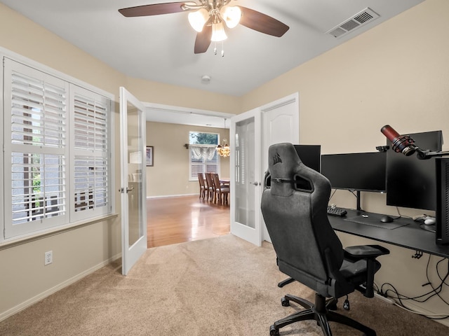 carpeted office space featuring french doors and ceiling fan