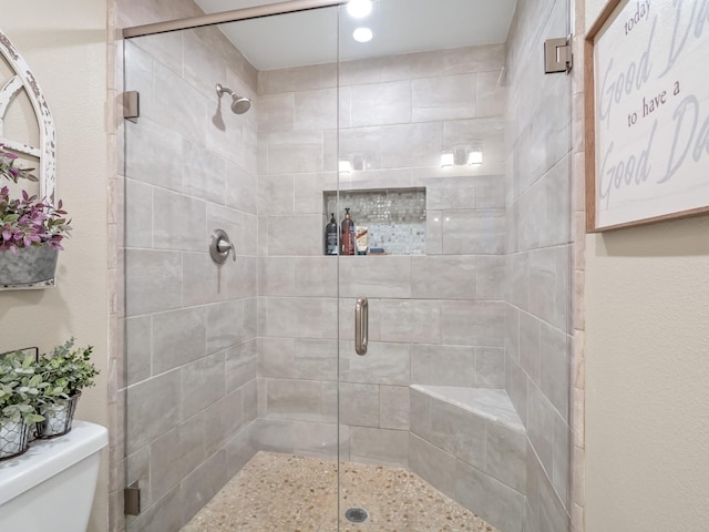 bathroom with toilet and a shower with shower door