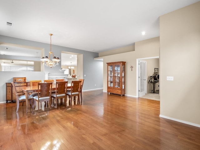 dining space featuring hardwood / wood-style flooring and a chandelier