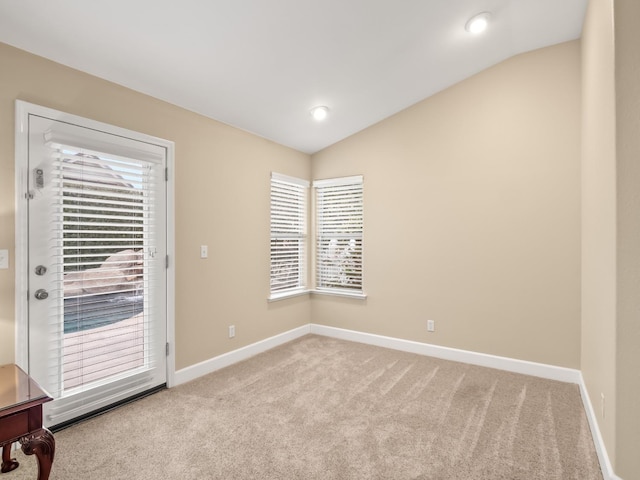 empty room featuring lofted ceiling and light colored carpet