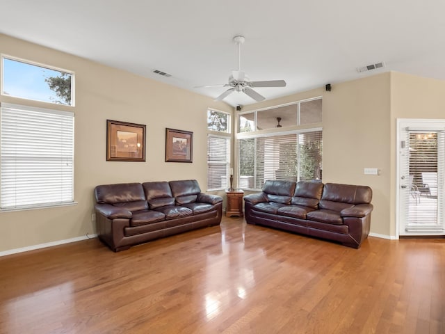 living room with ceiling fan, light wood-type flooring, and a wealth of natural light