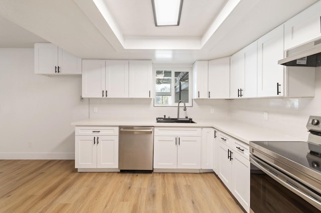 kitchen with light hardwood / wood-style floors, white cabinets, appliances with stainless steel finishes, and sink