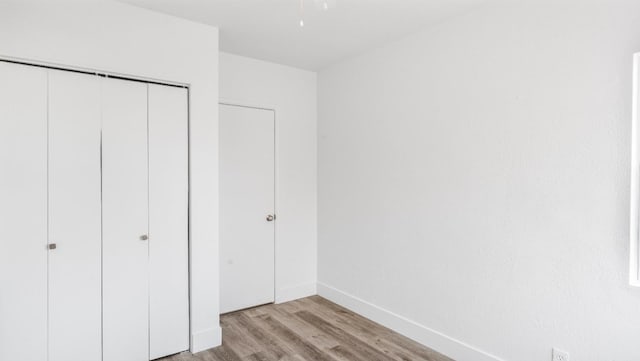 unfurnished bedroom featuring a closet and light hardwood / wood-style flooring