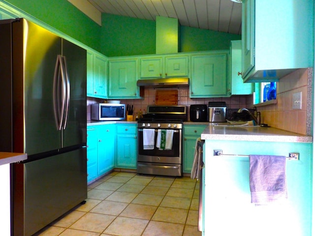 kitchen with vaulted ceiling, sink, decorative backsplash, appliances with stainless steel finishes, and light tile patterned floors