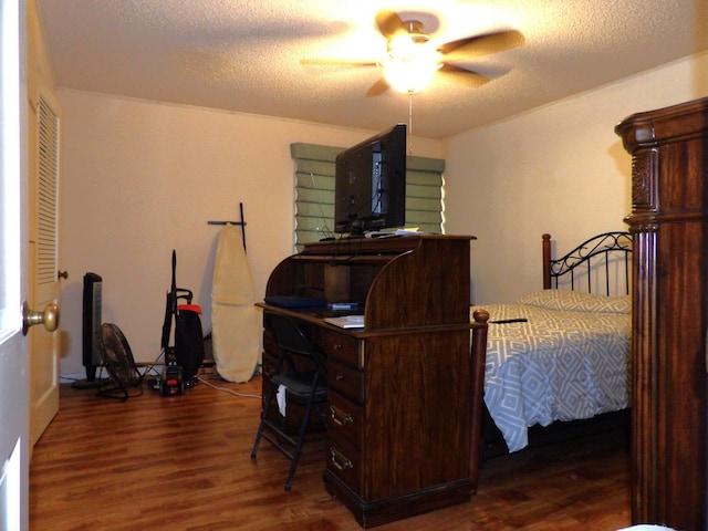 bedroom featuring ceiling fan, dark hardwood / wood-style floors, and a textured ceiling