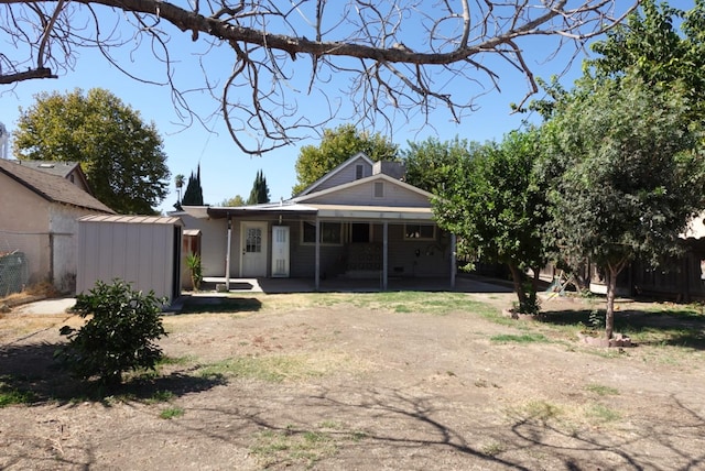 rear view of house with a shed and a carport