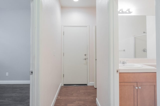 hallway with dark wood-type flooring and sink