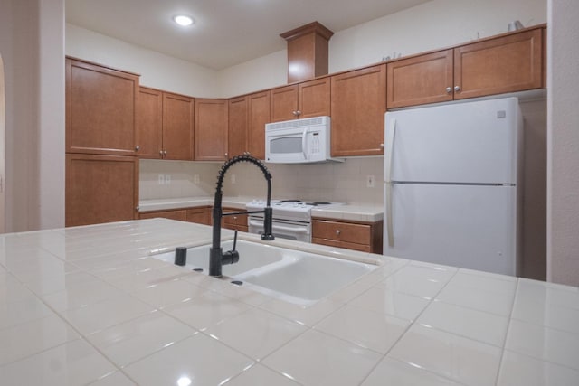 kitchen with tile countertops, white appliances, decorative backsplash, and sink