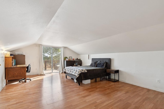 bedroom with access to outside, lofted ceiling, and light hardwood / wood-style flooring