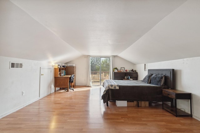 bedroom with lofted ceiling, light hardwood / wood-style floors, and access to exterior