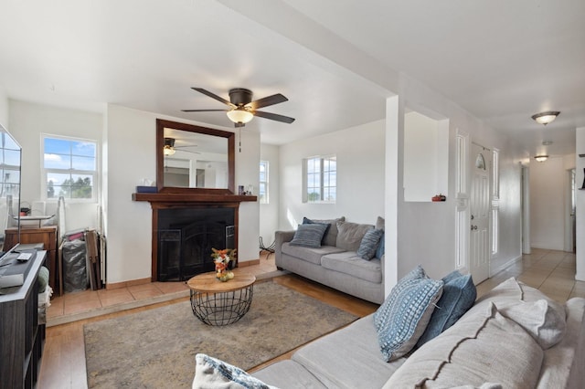 living room with a wealth of natural light, ceiling fan, and light hardwood / wood-style flooring