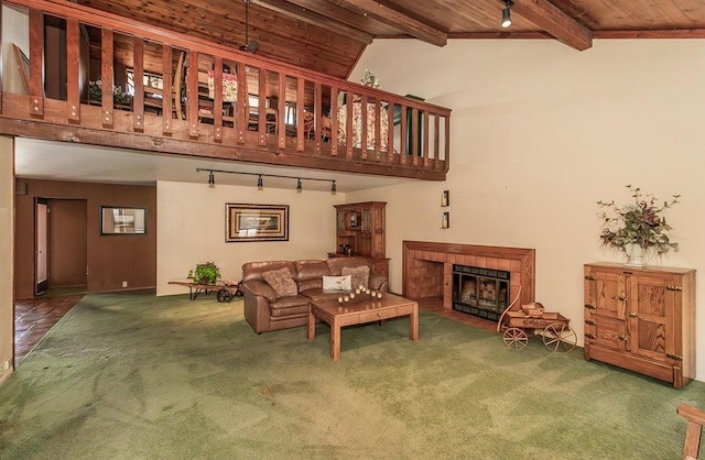 living room featuring carpet, lofted ceiling with beams, a tiled fireplace, wooden ceiling, and track lighting