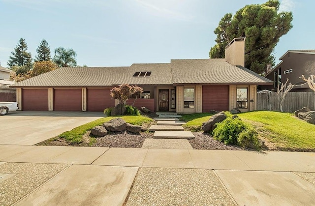 1531 E Avila, Tulare, CA 93274 - view of front facade with fence, driveway, a chimney, and a garage