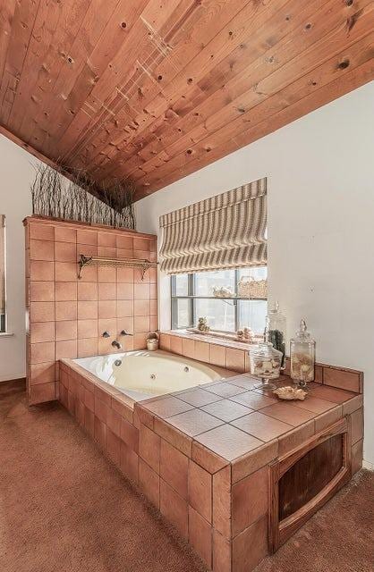 kitchen with dark carpet, tile countertops, vaulted ceiling, and wood ceiling