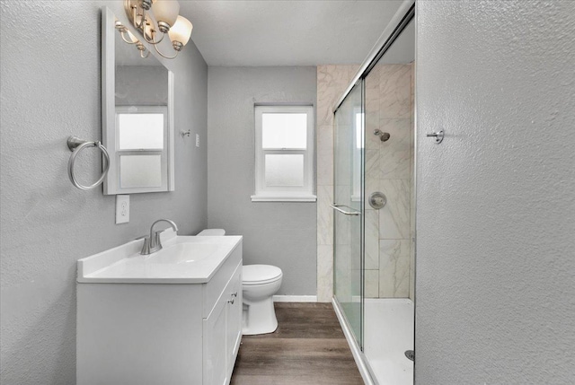 bathroom with hardwood / wood-style floors, vanity, toilet, and a shower with door