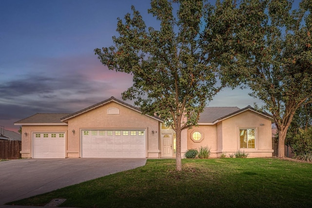 ranch-style house with a garage and a yard