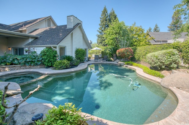 view of swimming pool featuring a patio and an in ground hot tub