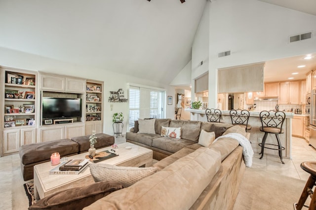 living room featuring light tile patterned floors and high vaulted ceiling