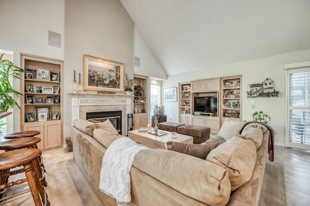 living room featuring built in features, high vaulted ceiling, visible vents, a premium fireplace, and baseboards