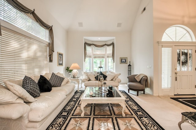 living room with high vaulted ceiling, visible vents, and carpet floors