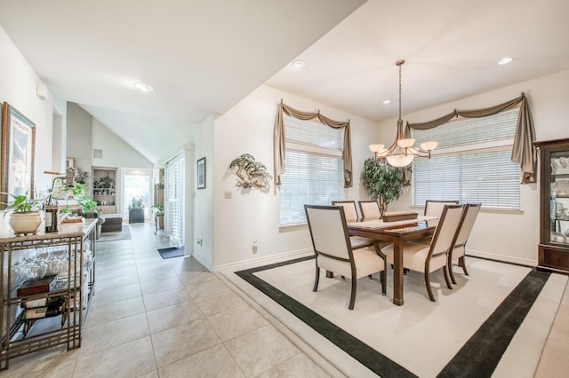 tiled dining area featuring vaulted ceiling, a notable chandelier, and a healthy amount of sunlight