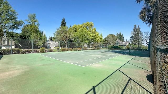view of tennis court featuring fence