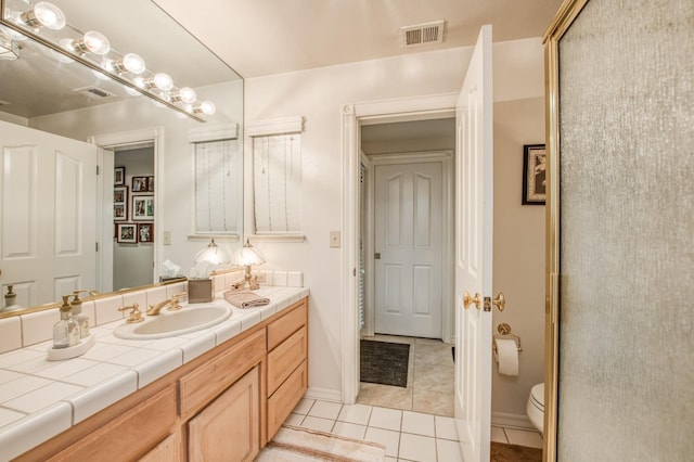 bathroom featuring tile patterned flooring, vanity, and toilet