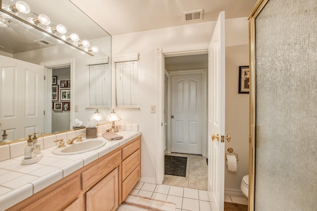full bathroom featuring toilet, tile patterned floors, vanity, and visible vents