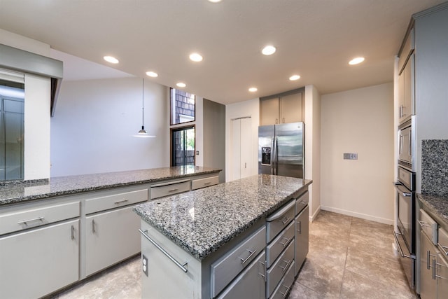 kitchen with gray cabinetry, a center island, light stone countertops, and stainless steel appliances