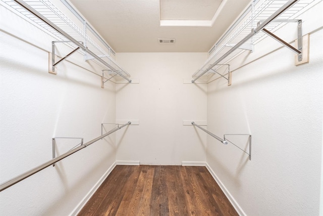 walk in closet with dark hardwood / wood-style flooring