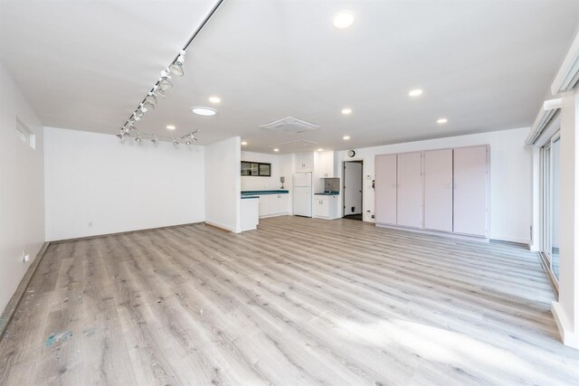 unfurnished living room with light wood finished floors, baseboards, track lighting, and recessed lighting