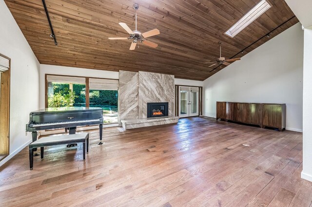living room featuring high vaulted ceiling, a high end fireplace, wood finished floors, a ceiling fan, and wood ceiling