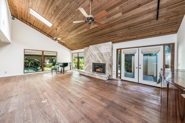 unfurnished living room featuring high vaulted ceiling, wood finished floors, a ceiling fan, french doors, and wooden ceiling