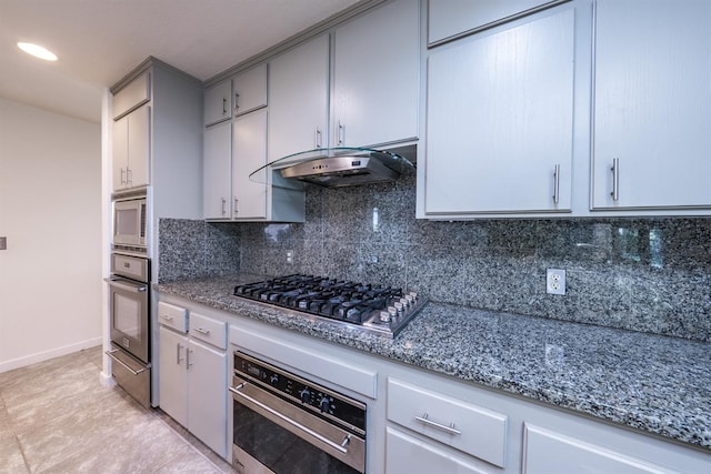 kitchen with tasteful backsplash, gray cabinets, stone counters, and appliances with stainless steel finishes