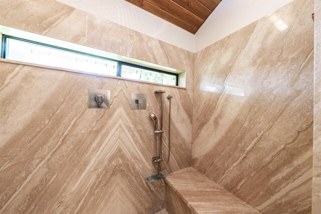 full bath featuring lofted ceiling and a tile shower