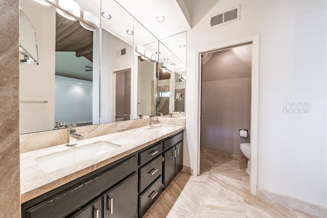 bathroom featuring a sink, double vanity, visible vents, and toilet