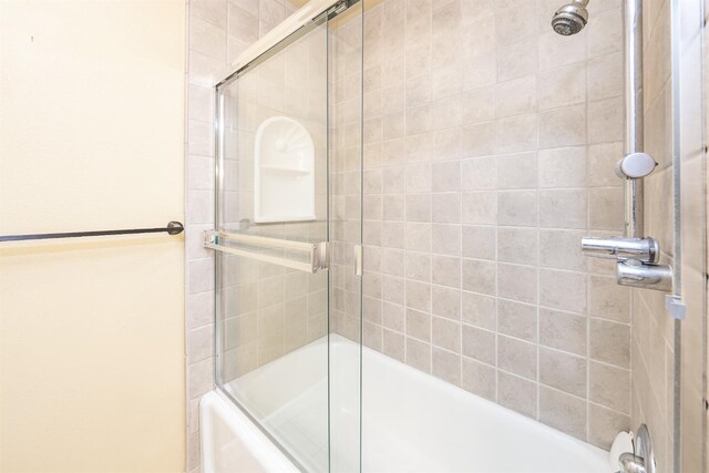bathroom with combined bath / shower with glass door