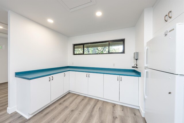 kitchen with white cabinets, recessed lighting, light wood-style floors, and freestanding refrigerator