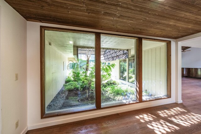 interior space featuring baseboards, wood finished floors, and wood ceiling