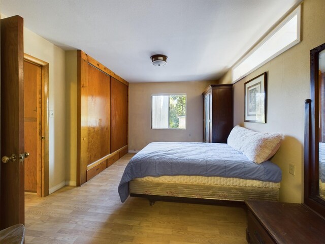 bedroom with a closet and light hardwood / wood-style floors