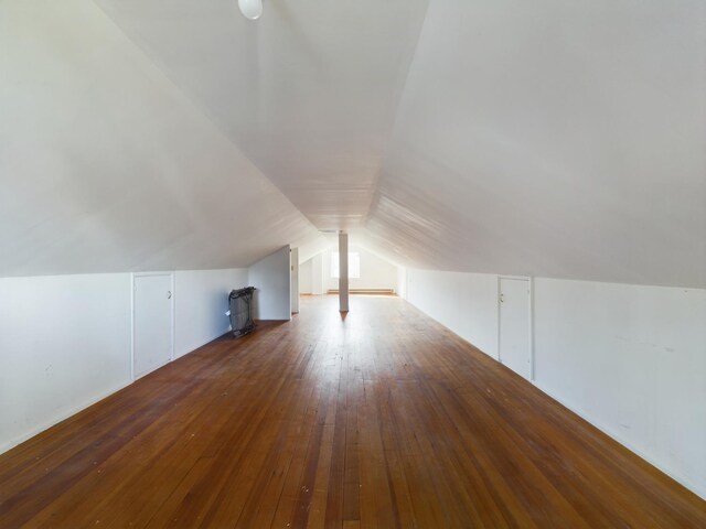 additional living space featuring dark hardwood / wood-style floors and vaulted ceiling