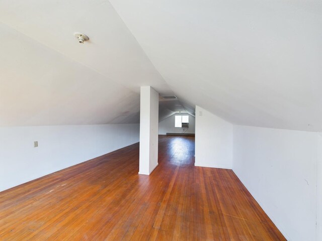 additional living space featuring lofted ceiling and dark hardwood / wood-style floors